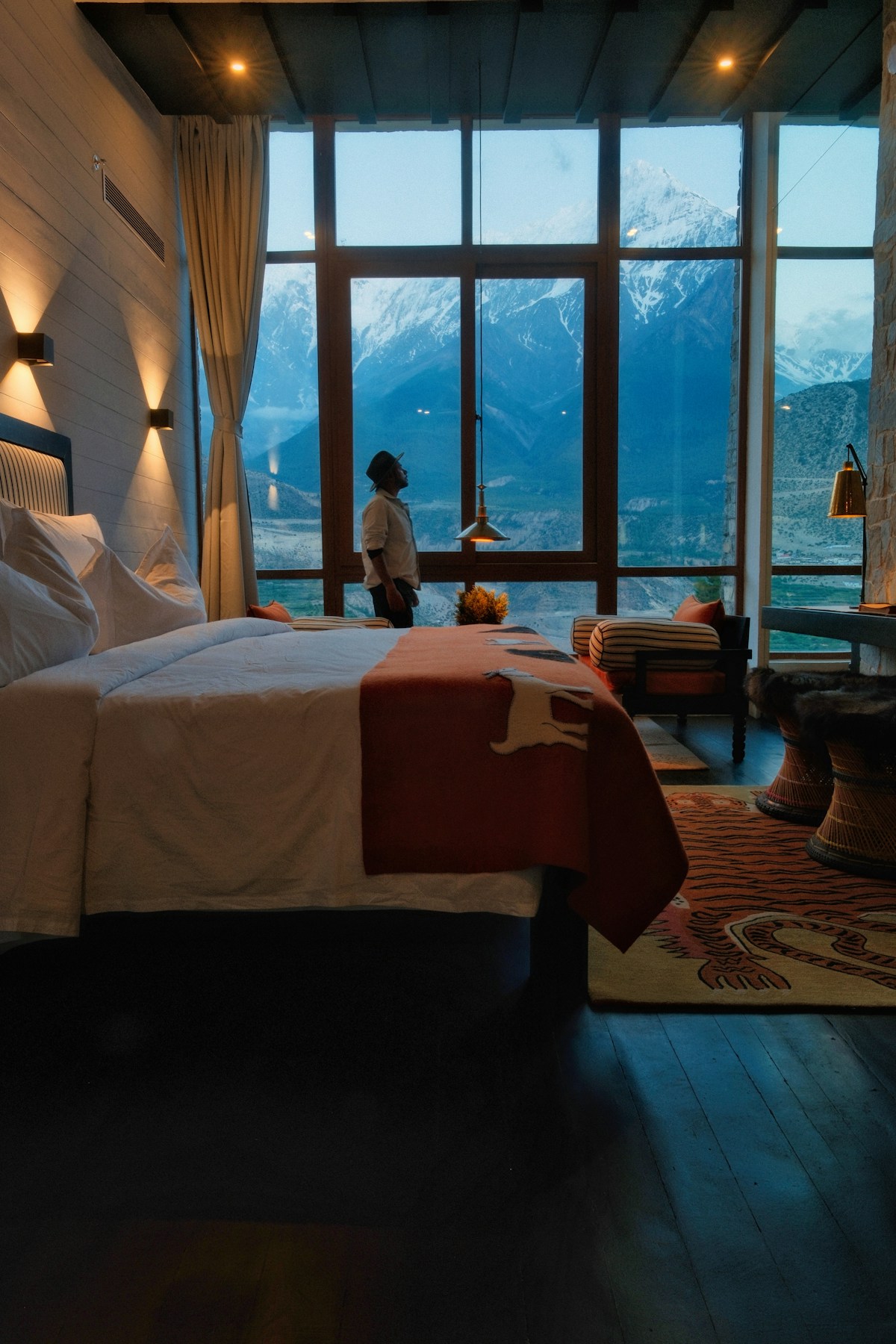Spacious 3-star hotel room with snow-capped mountains beyond a panoramic window